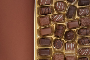 chocolate candy set. Box of chocolates  on a  dark brown background.assorted chocolate sweets.Chocolate candies set in an open box. top view.sweet dessert closeup