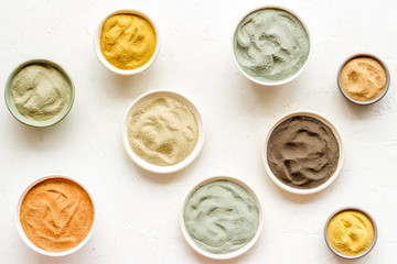 Blue, yellow, white. red, black cosmetic clay background on white table top-down pattern