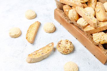 Various cookies in a wooden tray on gray background