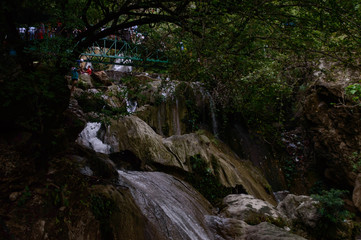 Group of people enjoying under the famous neer garh Waterfall, Rishikesh, Uttarakhand India.