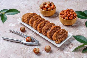 Delicious sweet chocolate cake roll with hazelnut cream and hazelnuts,top view