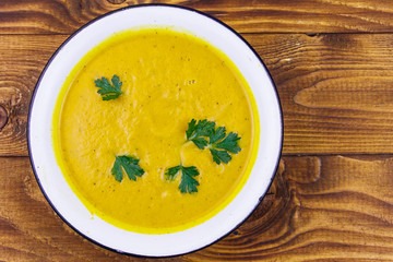 Pumpkin soup on a wooden table. Top view
