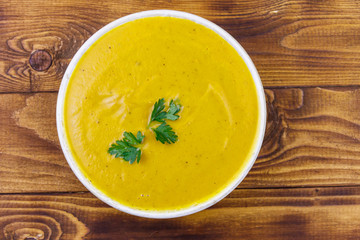 Pumpkin soup on a wooden table. Top view