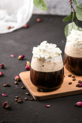 Ice coffee in a glass with wrapped cream