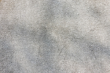 Exposed aggregate concrete in closeup made of small pebbles in different grey color shade