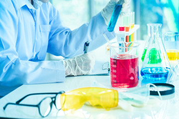 Asian Scientist Pipetting at a Biomedical Laboratory.Focused young life science professional...