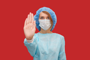 Portrait of doctor in scrubs. A female doctor in a protective cap and face mask in safety measures against the coronavirus.