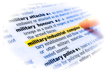 A close up of the word: MILITARY-INDUSTRIAL COMPLEX in a dictionary, highlighted in yellow and showing part of its definition.