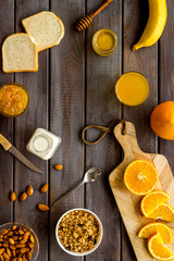 Granola for healthy breakfast. Still life composition with fruits and toast on wooden background top-down