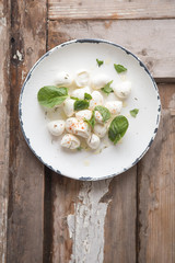 Mozzarella cheese balls in plate with mint . Traditional Italian food concept. Top view
