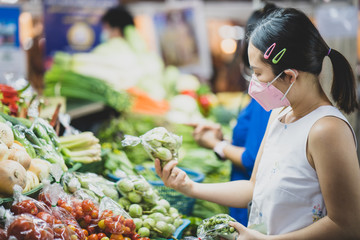 Beautiful young woman wearing protective medical mask preventing flu, pollution and covid 19 at local market.