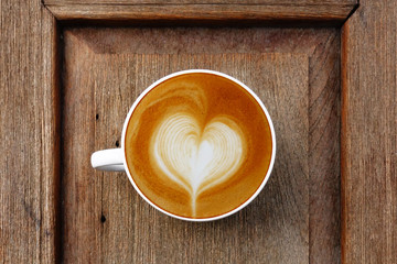 a cup of latte art coffee on wooden background                                                                                                                                                          