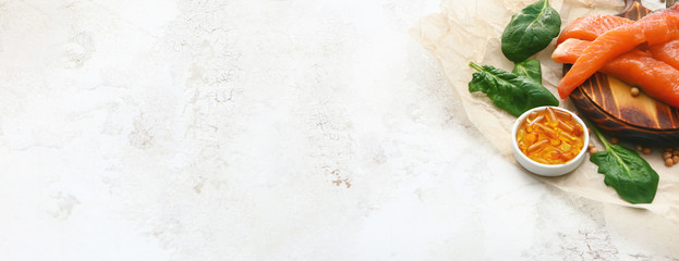 Fish with oil pills on light background with space for text