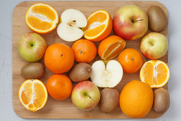 fruit diversity on wooden kitchen Board on grey background of sliced and whole fruits