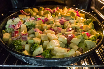 Finely chopped and seasoned vegetables for cooking in the oven. Potatoes, bell peppers, zucchini and broccoli. Healthy food close-up