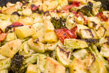Vegetable stew, oven baked vegetables. Finely chopped and seasoned potatoes, bell peppers, zucchini and broccoli. Healthy food close-up