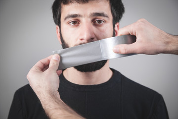 Caucasian man with tape on mouth. Censorship