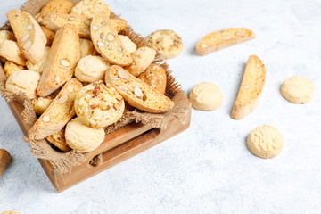 Various cookies in a wooden tray on gray background
