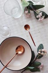  ceramic plates and copper spoons on a serving table. view from above.