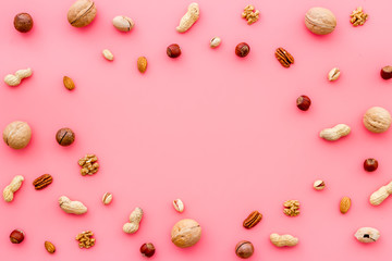 Nuts background - healthy snacks concept - on pink table top-down frame copy space