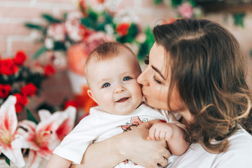 Mother's day. Young beautiful mother hugging with her little baby daughter, cute and smiling, happy, together stay at home.