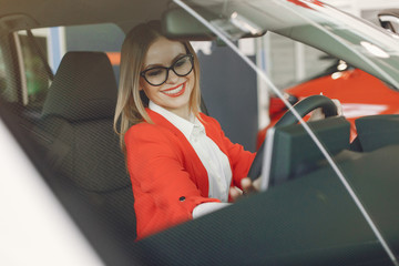 Lady in a car salon. Woman buying the car. Elegant woman in th ecar interior.