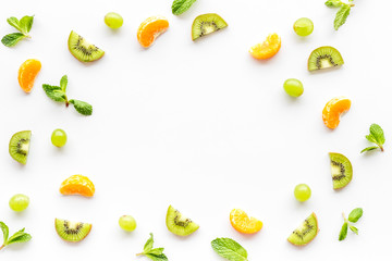 Slices fruites frame. Fruit salad concept with citruses, aplle and kiwi on white background top-down copy space