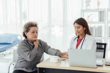 Asian doctor working in the office and discussing  to the patient about her symptoms, healtcare and hospital concept.