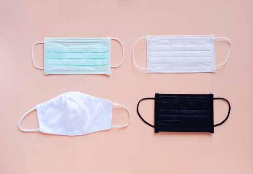 Flat lay of various kind and color of hygienic masks on bright pastel peach orange color background, health care and prevent the spread of pandemic Covid-19 and Coronavirus,