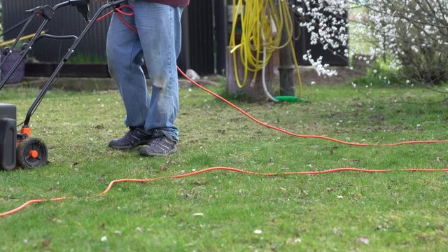 A man using a lawn aerator in the garden