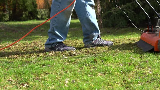 A man using a lawn aerator in the garden