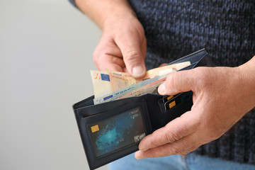 Senior man with purse on grey background, closeup