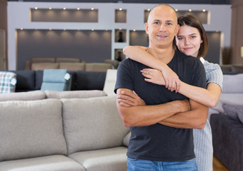 Obraz premium Husband and wife posing in room with sofas