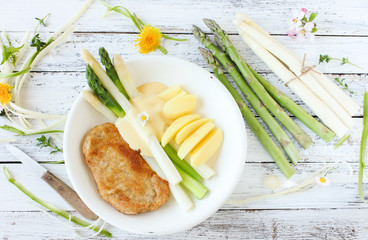 Teller mit frischem Spargel weiß grün weißer grüner mit Schnitzel und Kartoffel