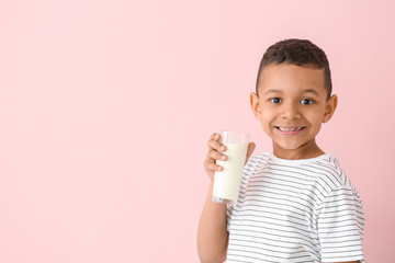 African-American boy with milk on color background