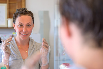 Woman looking at herself in a bathroom mirror