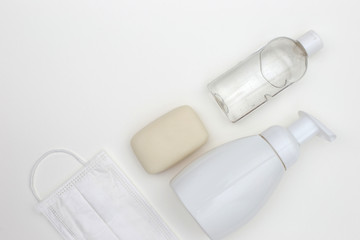 bottle of antibacterial soap and bottle antibacterial gel for hands, bar of soap, madical mask. Flat lay