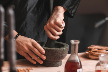 Fototapeta na wymiar Male alchemist making elixir in laboratory, closeup