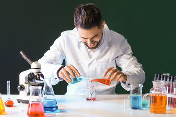 Male alchemist with potions at table