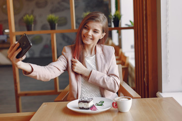 Girl in a cafe. Woman in a pink jacket. Lady have a breakfast.