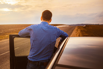 Fototapeta premium Men near the car at sunset