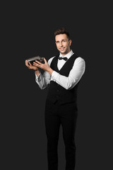 Handsome male bartender on dark background