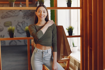 Beautiful girl in a cafe. Lady with shopping bags. Woman in a gray top.