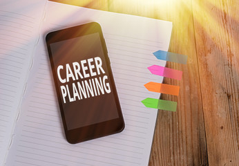 Writing note showing Career Planning. Business concept for Strategically plan your career goals and work success Striped note book colored arrow banners smartphone wooden background