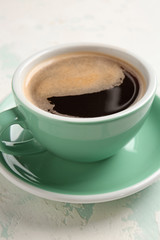 Cup of hot coffee on light background