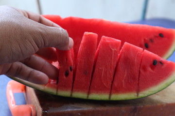 young woman cutting watermelon