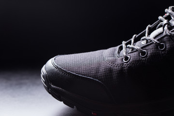 Black men's sneakers close-up on a black isolated background.