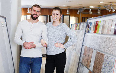 Young family couple standing near ceramic  tile  in shop