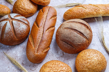 Different kinds of fresh bread as background, top view