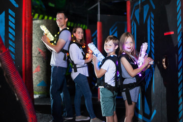 Obraz na płótnie Canvas Kids standing back to back with laser pistols